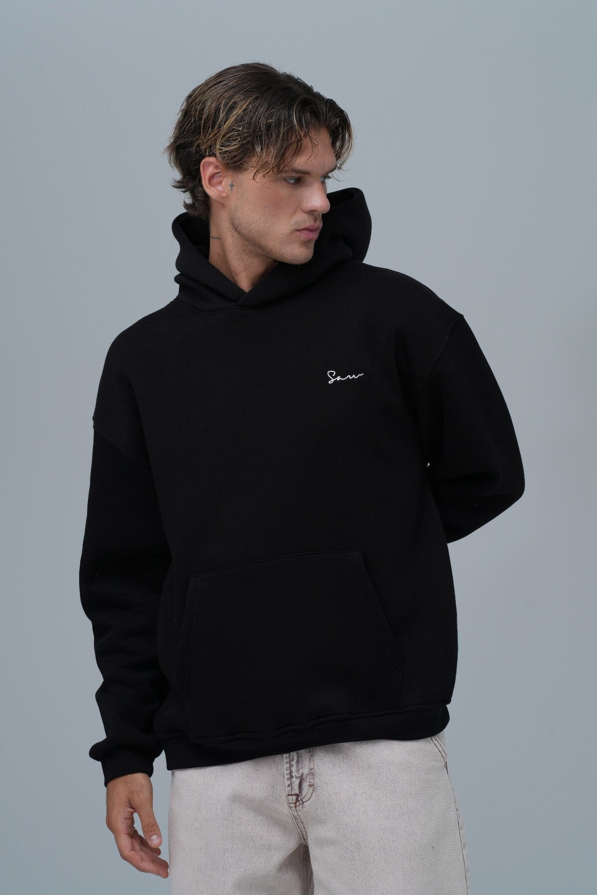 Model wearing the Framed Elegance Hoodie in Black by KOVA Amsterdam