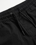 Close-up of black shorts with elasticated waistband and adjustable drawstring